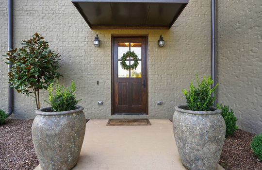 front door, covered entry, landscaping, brick exterior
