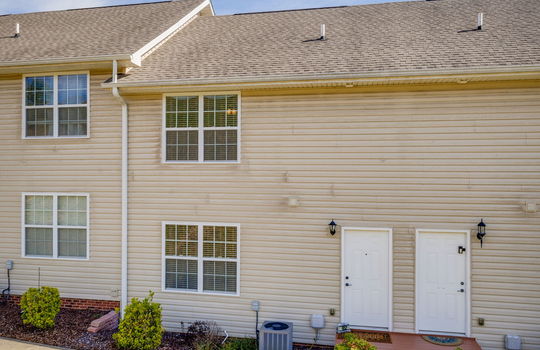 Townhouse, vinyl siding, neighboring townhouses, stoop, landscaping, shingle roof