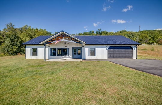 Farmhouse, Barndominium, Metal Siding, Metal Roof, covered front porch, driveway, garage, garage door, yard, front door, double door entry, windows