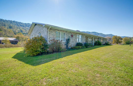 left side view of home, brick, ranch, metal roof, covered front porch, carport, front yard, side yard, mountain views