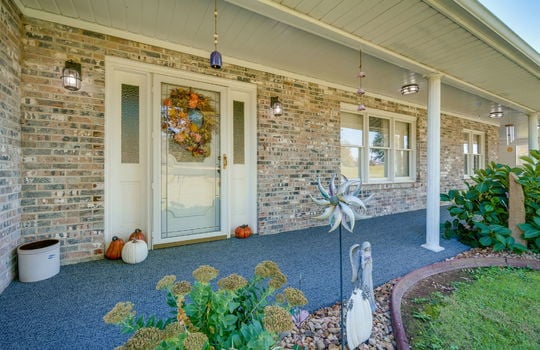 front porch, covered front porch, front door, storm door, landscaping, carpeted covered porch