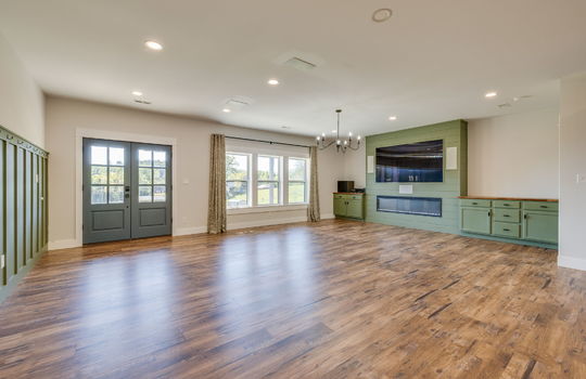 living room, windows, double door entry, built-in cabinetry, electric fireplace, recessed lighting, luxury vinyl flooring