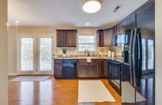 kitchen, cabinets, countertops, kitchen/dining combo, dishwasher, built-in microwave, oven/range, refrigerator, sink, window above sink, hardwood flooring, double door to balcony.