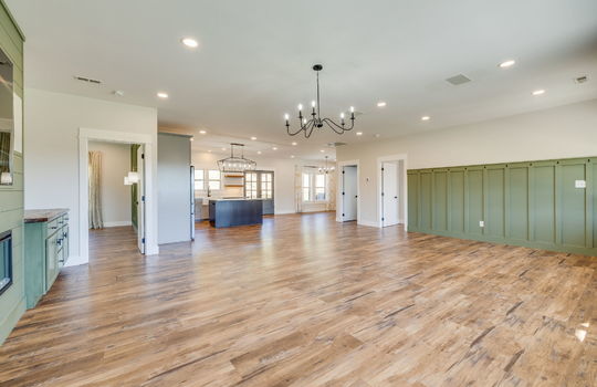 living room, door to bedrooms, open floorplan, luxury vinyl flooring, kitchen, kitchen island, dining space, recessed lighting