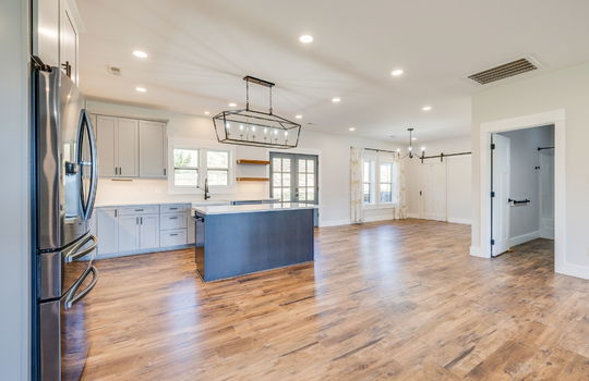 kitchen, luxury vinyl flooring, refrigerator, kitchen island, cabinets, countertops, dining area, recessed lighting
