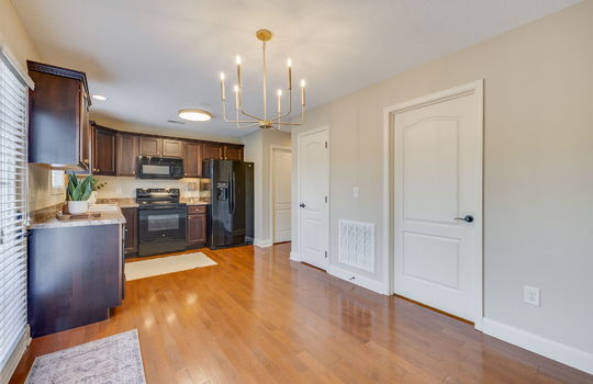 kitchen/dining combo, hardwood flooring, cabinets, countertops, oven/range, built-in microwave, refrigerator, doors, door to balcony