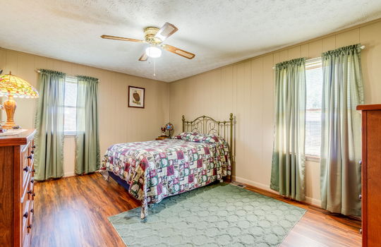 bedroom, laminate flooring, windows, painted paneling walls, ceiling fan