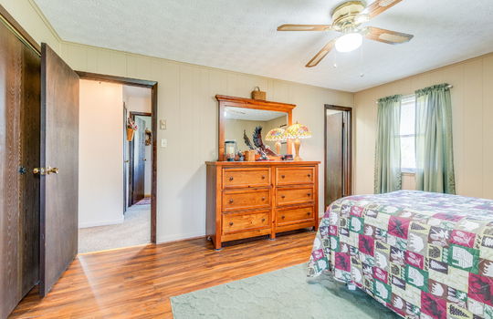 bedroom, painted paneling walls, closet, ceiling fan, laminate flooring, doorway, windows