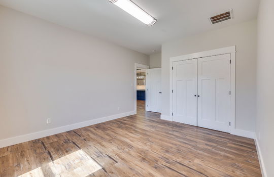 second bedroom, closet, luxury vinyl flooring, fluorescent lighting