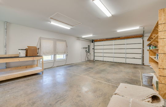 garage, garage door, windows, built-in shelving, concrete flooring. fluorescent lighting, attic entry