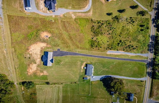 overhead aerial view of home, metal roof, back yard, front yard, driveway, neighboring homes, road