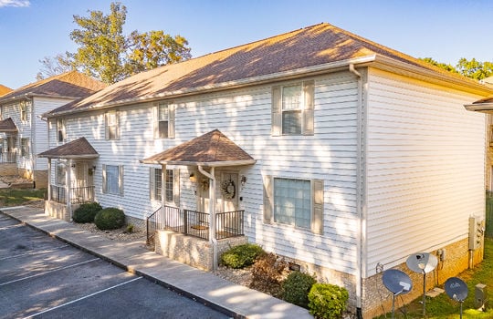 townhouses, parking lot, covered front porches, vinyl siding, landscaping, shingle roof