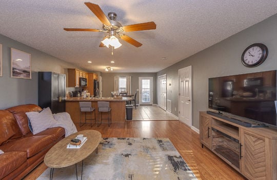 living room, open floorplan, kitchen, laminate flooring, tile flooring, ceiling fan
