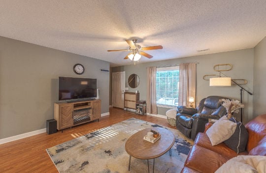 living room, laminate flooring, window, front door, ceiling fan