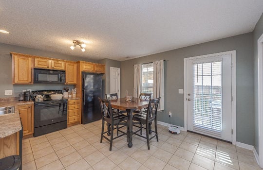 kitchen, tile flooring, cabinets, countertops, refrigerator, oven/range, built-in microwave, eat-in kitchen, door to back deck