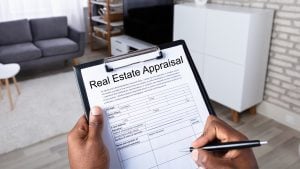 a man signing real estate appraisal on a paper
