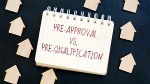 pre-approval vs. pre-qualification text on a paper around house-shaped boards