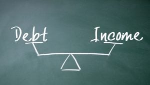 debt and income in a seesaw chalk drawing on a board