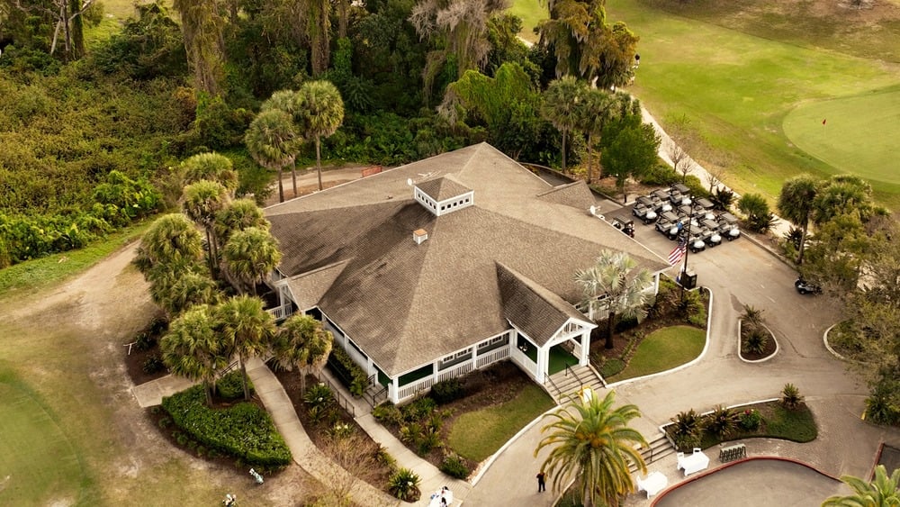 An aerial view of a home with a golf course in the background