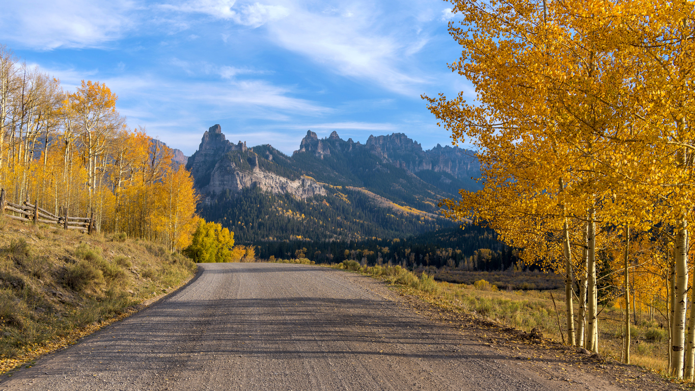 Autumn Mountain Road &#8211; An Autumn evening view of a backcountry road extending towards rugged mountain ridges. Owl Creek Pass Road, Cimarron-Ridgway, Colorado, USA.