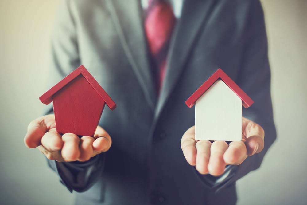 Man holding two houses for sale, listing agents in Dover NH