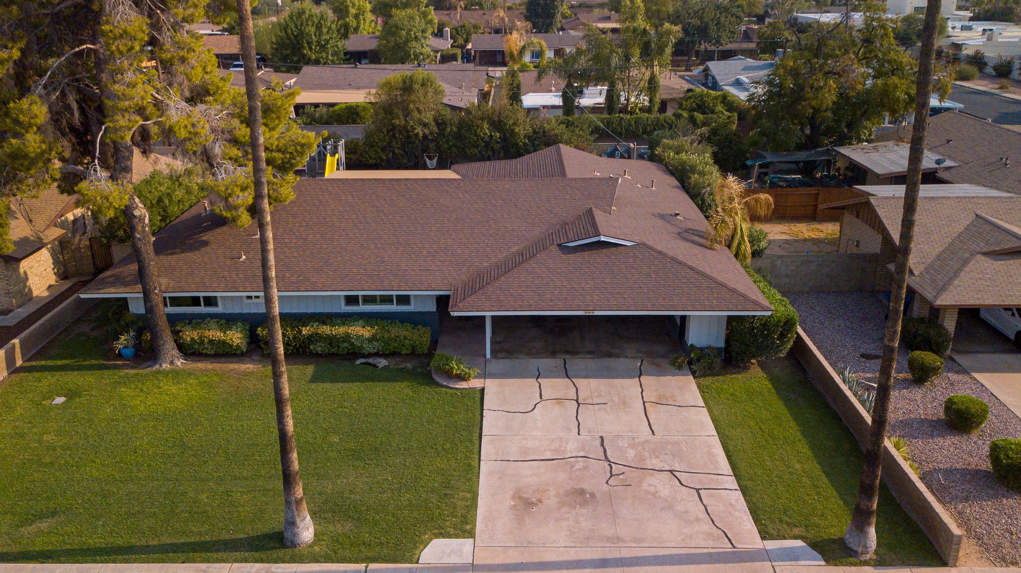 Drone view of a single family house and driveway in a quiet neighborhood