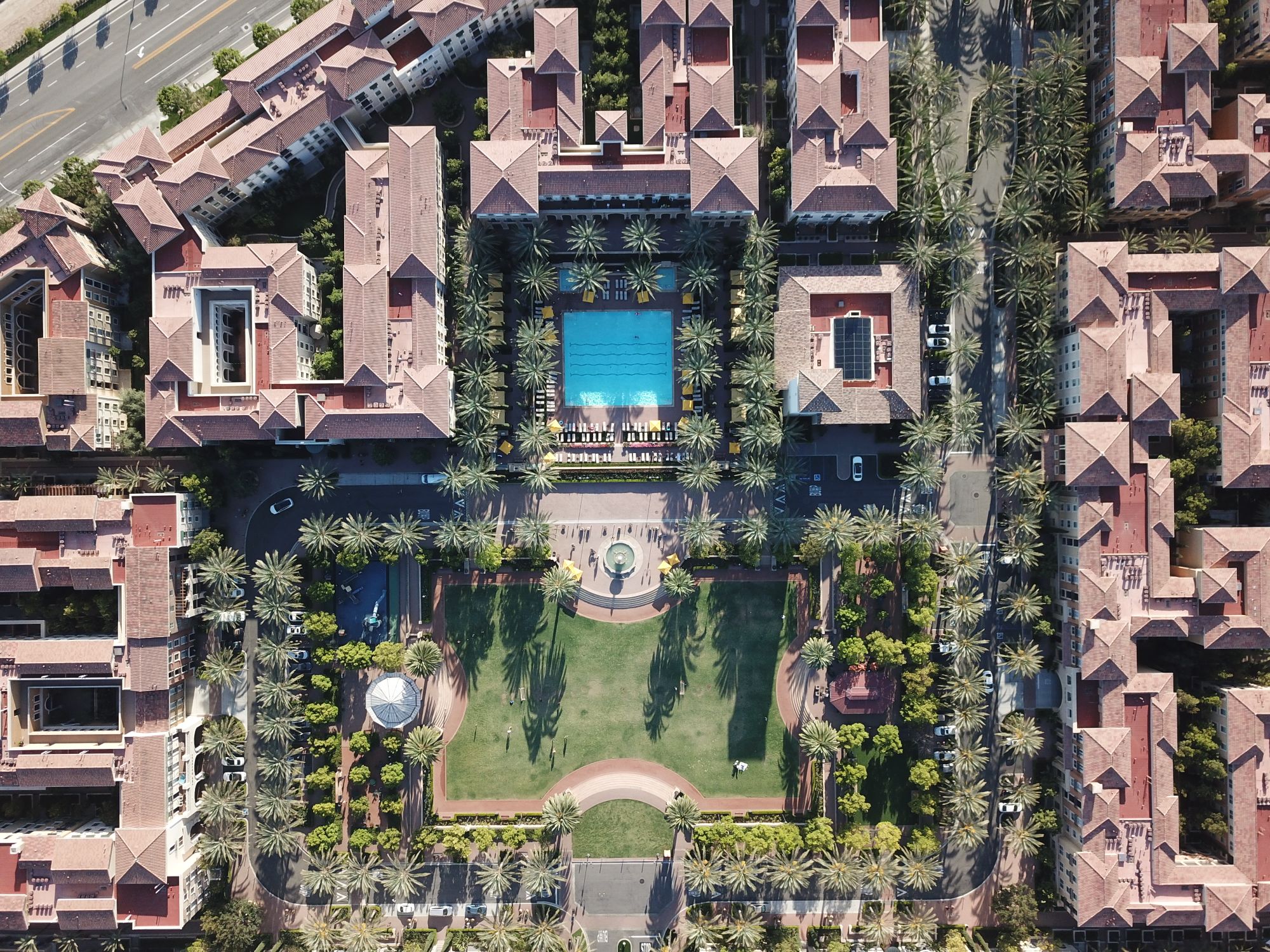 Aerial view of a planned residential community with a central pool and gardens