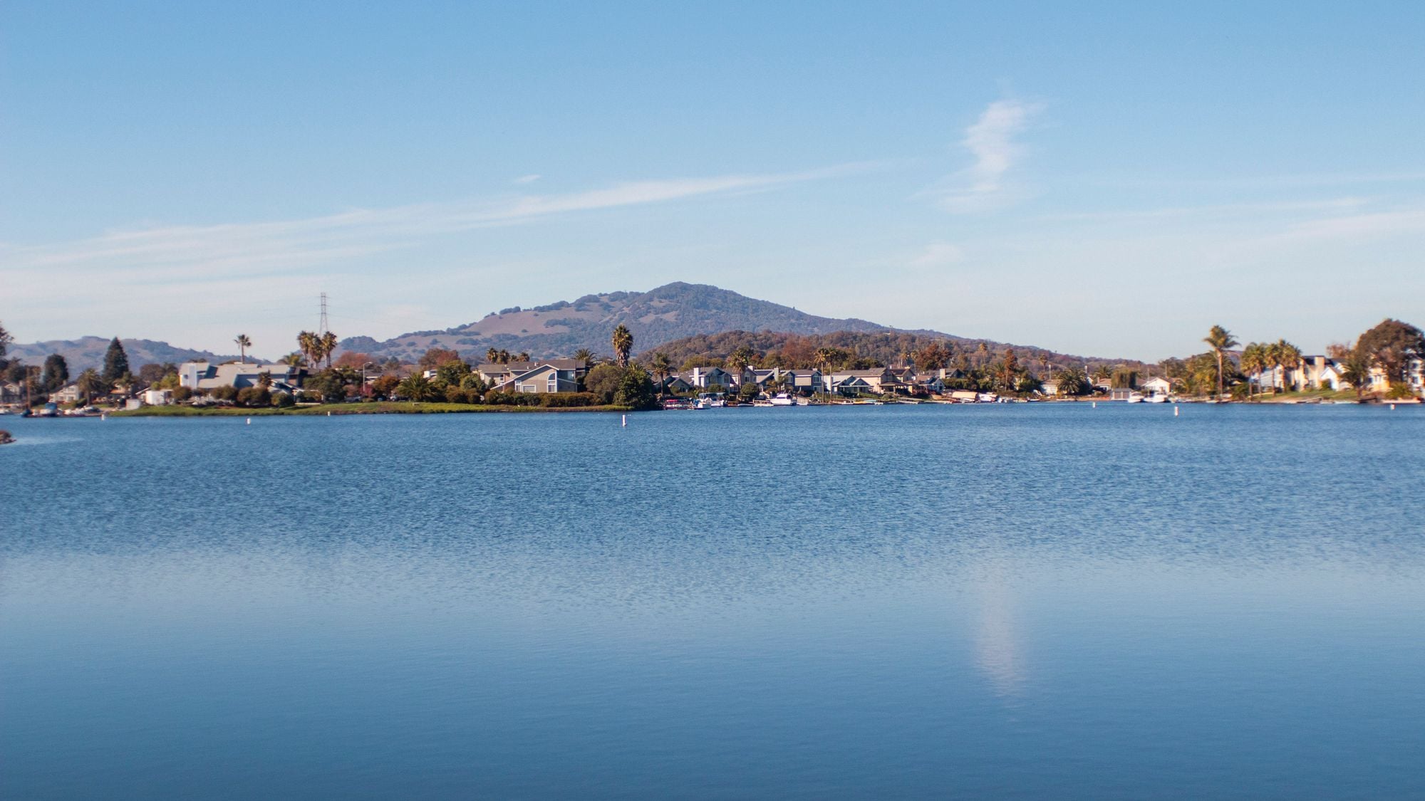 Homes beside a lake with hills rising behind them