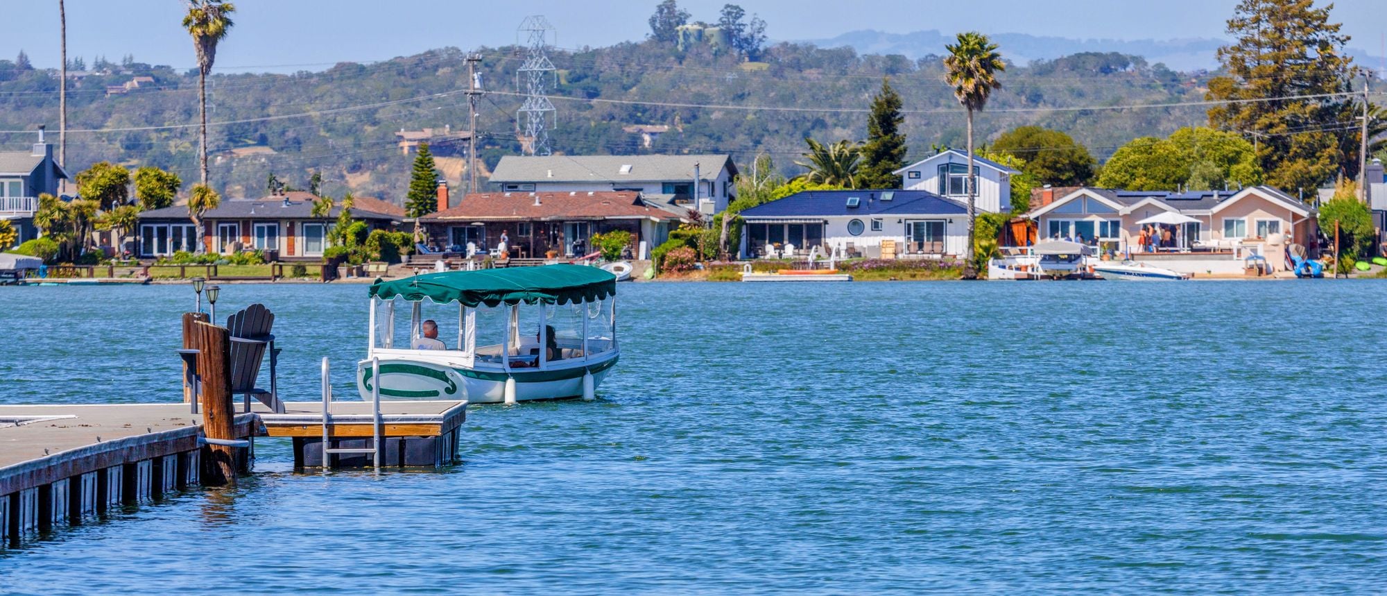 Homes and a small pier beside a lake on a sunny day