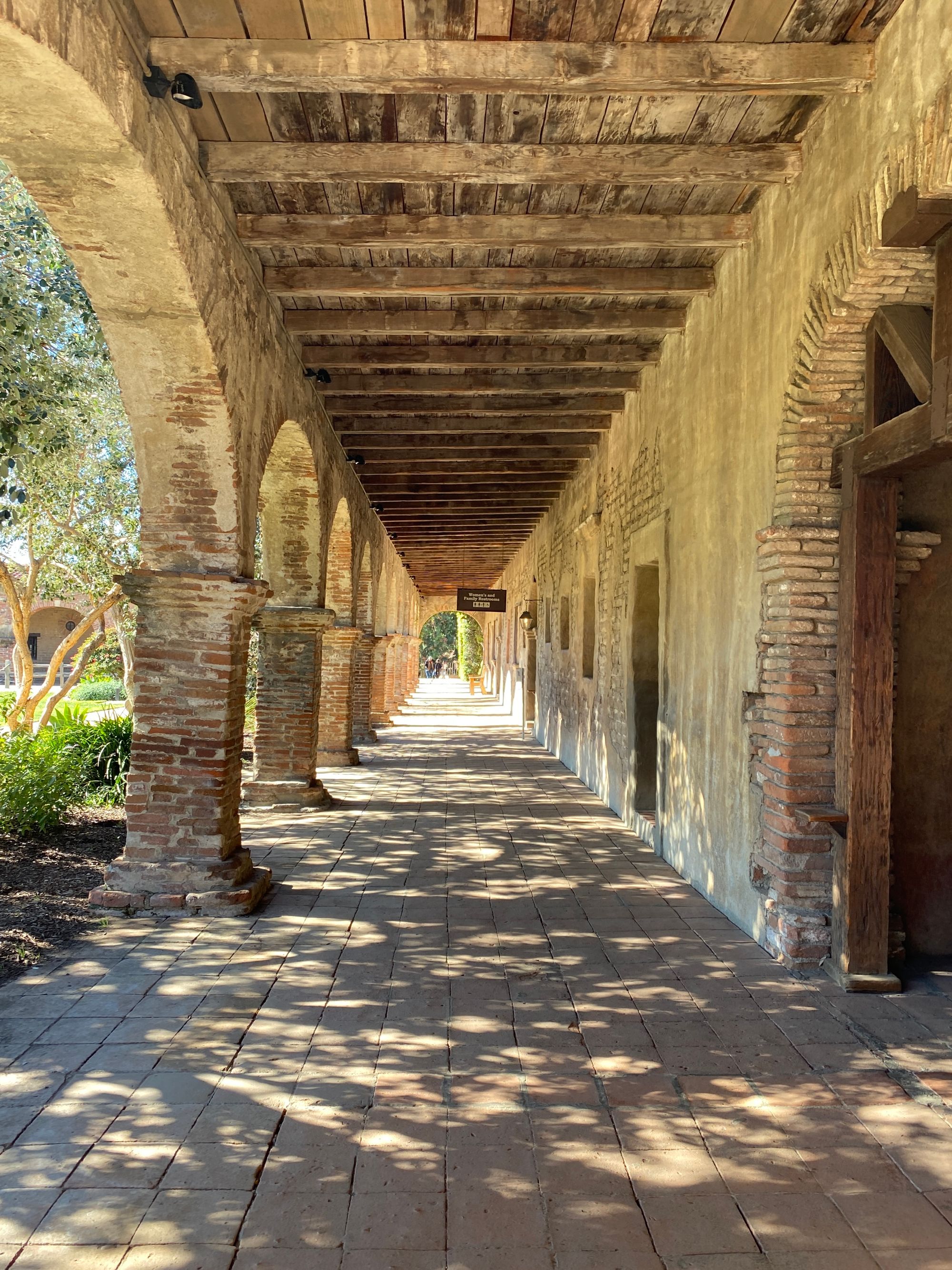 A sunlit arched corridor at Mission San Juan Capistrano