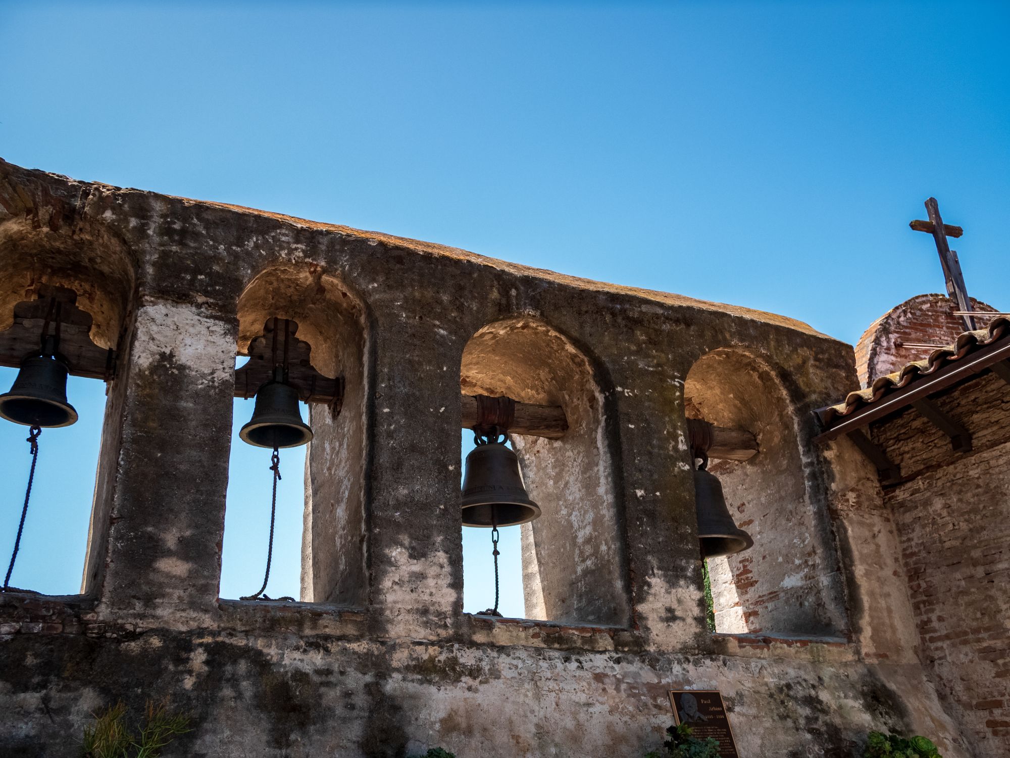 The bells at Mission San Juan Capistrano against a clear blue sky