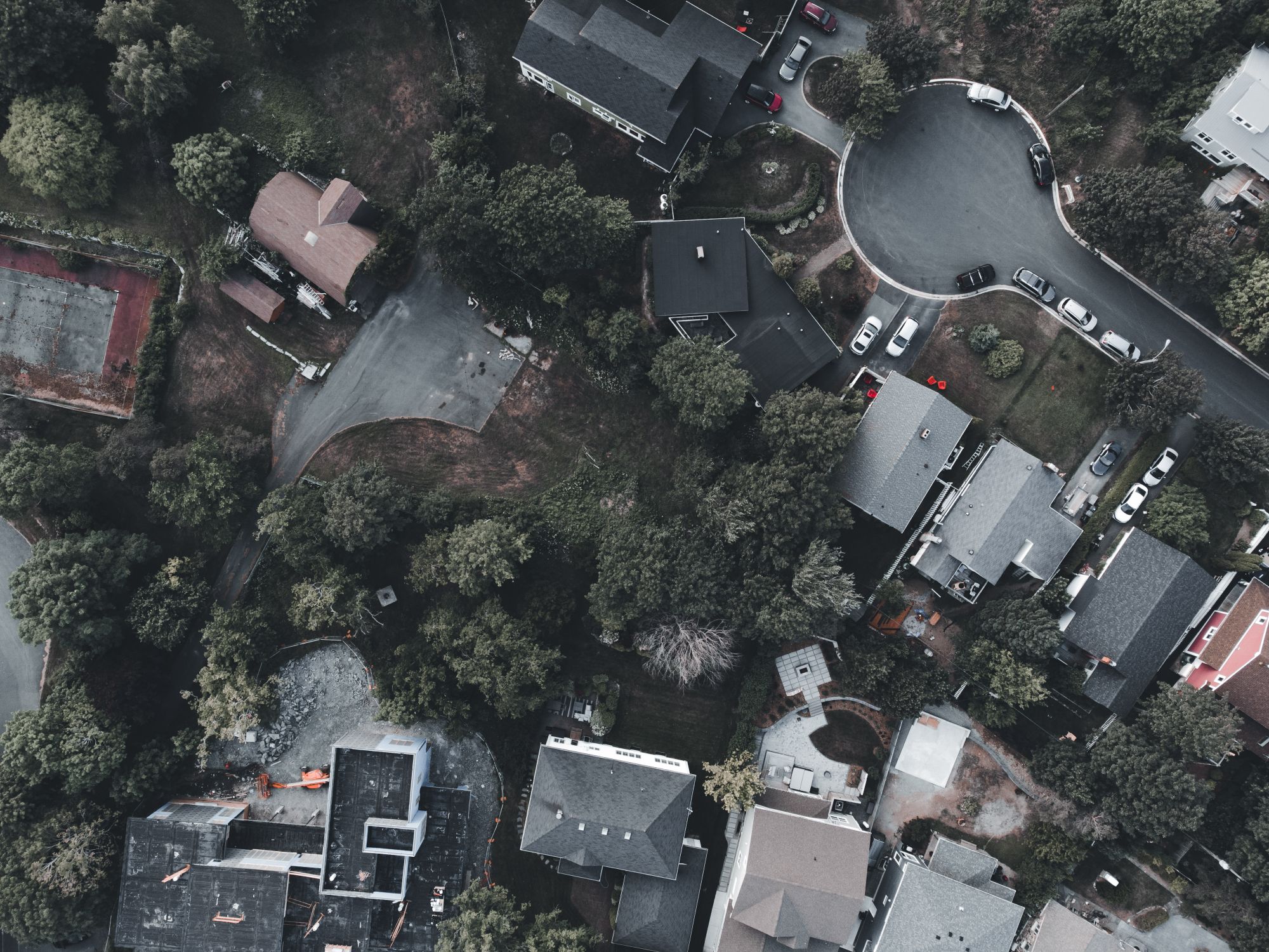 Top down view of a suburban neighborhood with houses, streets and greenery