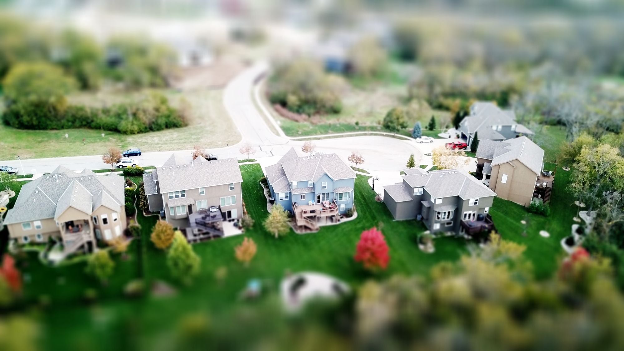 Aerial view of residential houses in a neighborhood with greenery and streets
