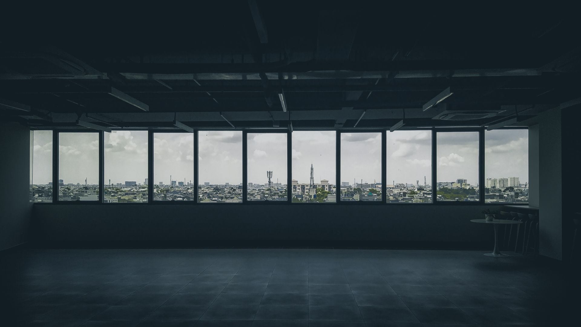 Empty high floor apartment with floor to ceiling windows looking out over a city skyline