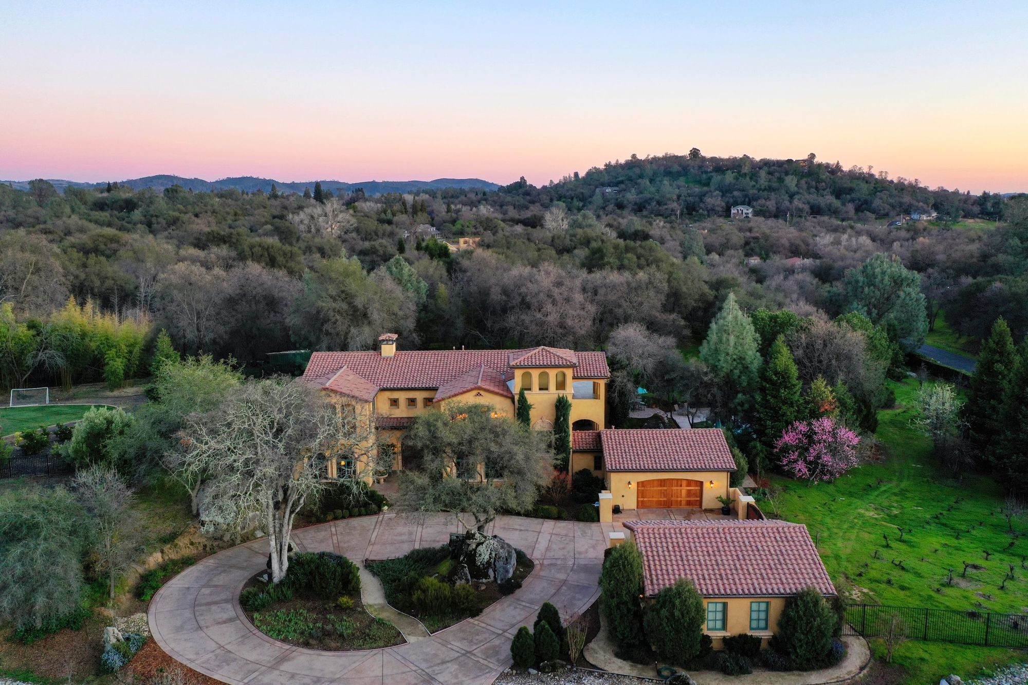 Aerial view of a Mediterranean style estate among wooded hills at dusk