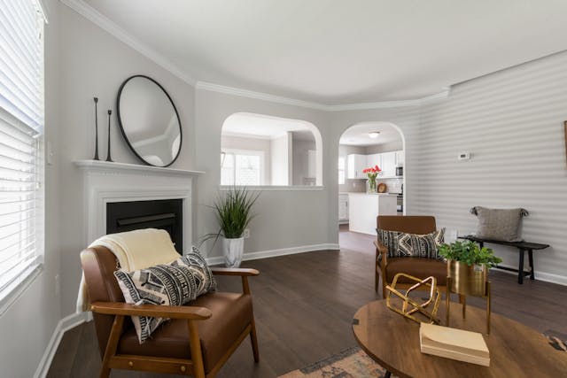 a white and grey living room with two brown leather chairs