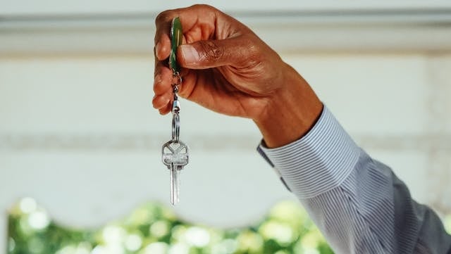 a hand holding up a house key