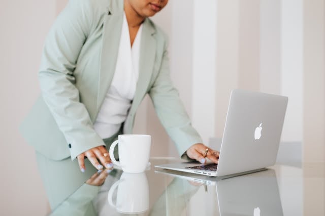 a person in a mint green suit looking at their laptop