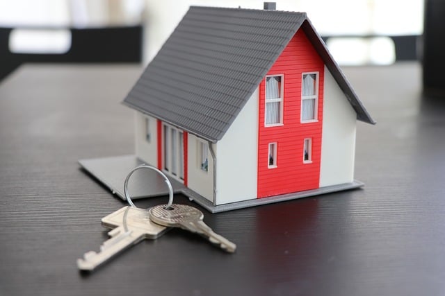 house keys sitting next to miniature house