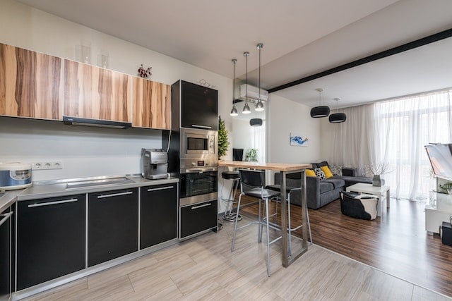 kitchen with black lower cabinets and wood upper cabinets and black appliances