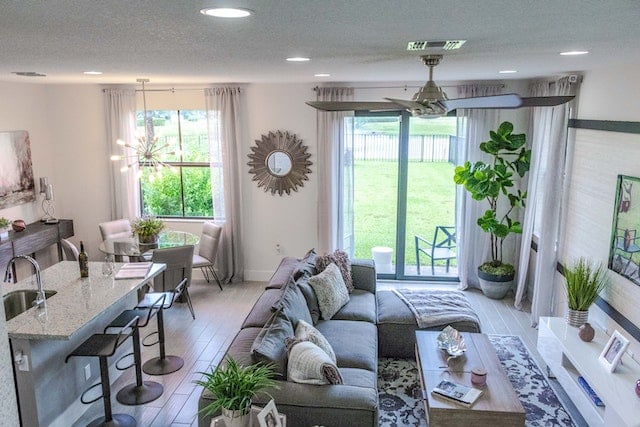 open concept living room and kitchen with white walls, gray furniture and large windows