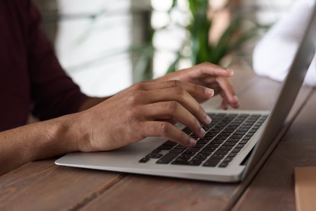 a person typing on their laptop