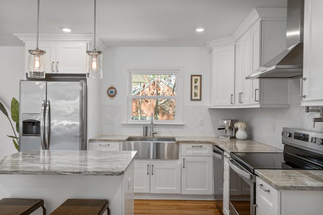 a white kitchen with stainless steel appliances