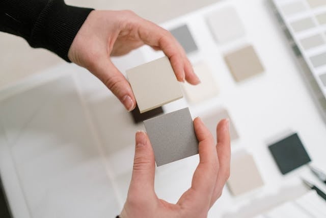 a person looking at paint and tile samples