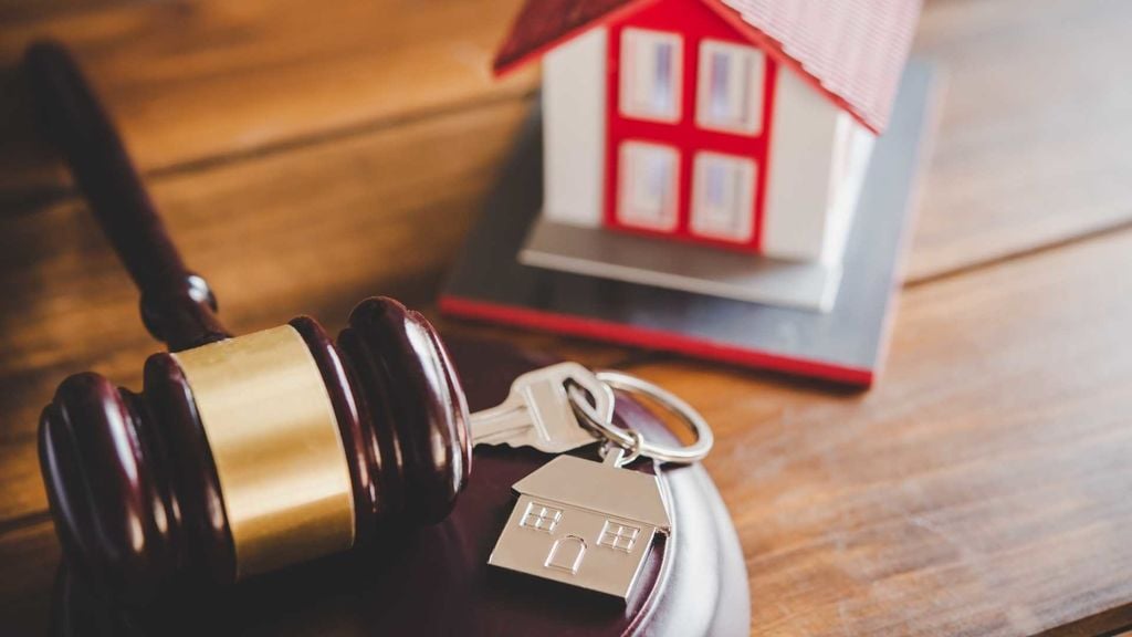 a gavel, house keys and a home figurine