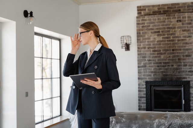 a real estate agent holding a clipboard while inspecting a home