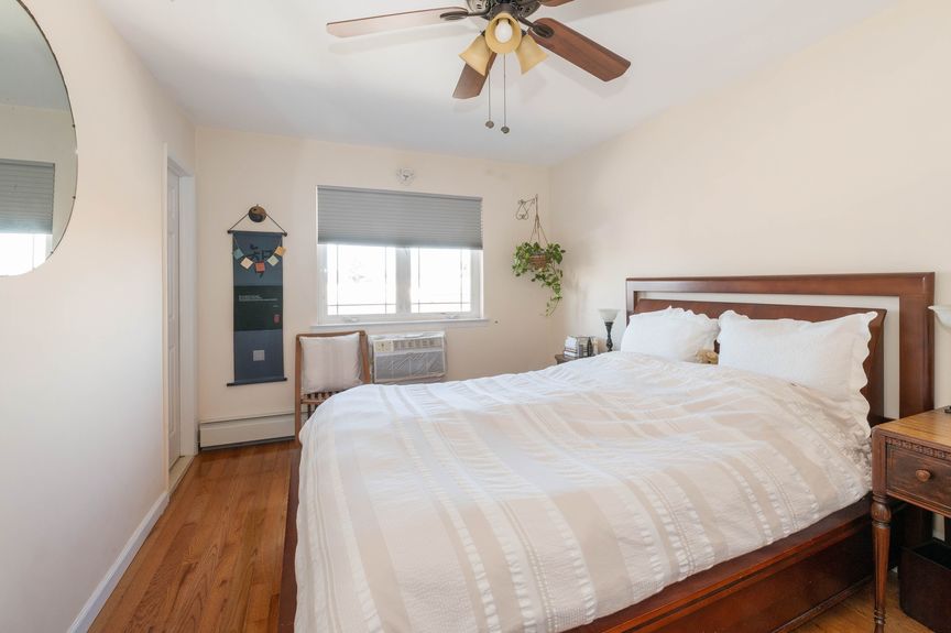 Bedroom 2 with spacious bed, glass window, and fan fixture