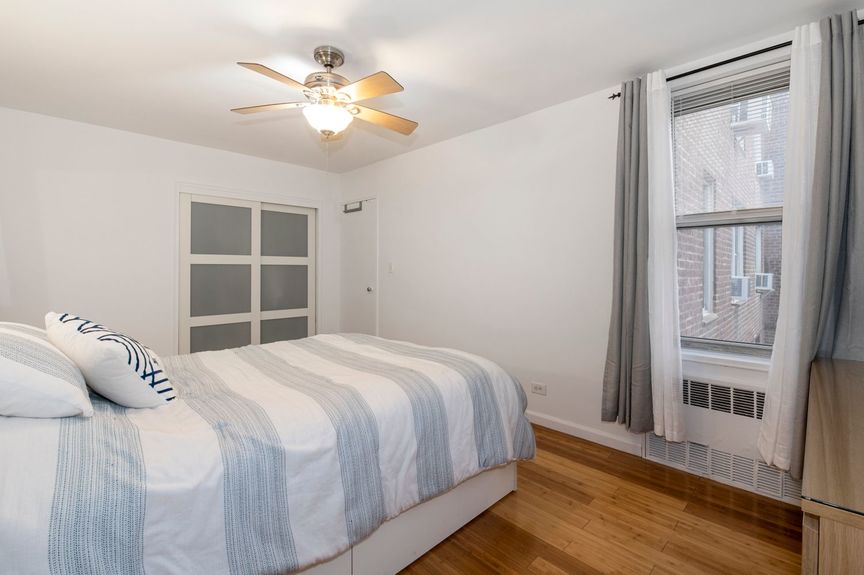 Bedroom with fandeliers and the window