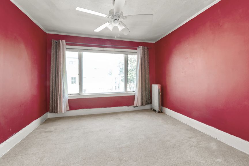 Third bedroom on the second floor with red wall paint