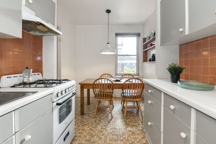 Kitchen with a view of a table, chairs, and a window